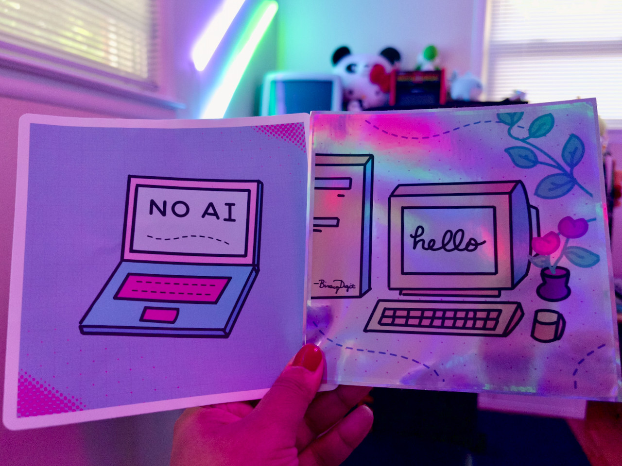 Two big sticker samples of my illustrations, including a “no ai” on a laptop and a “hello” computer on colorful backgrounds of blue, pink, teal and green.