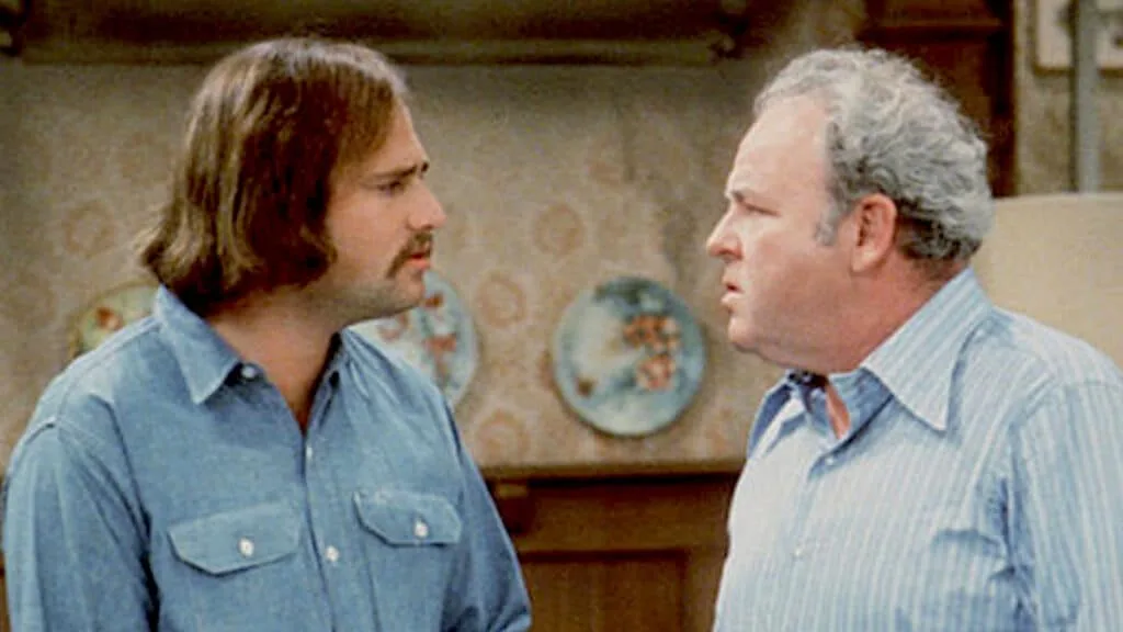 Meathead (Rob Reiner) and Archie Bunker (Carroll O'Connor) looking at each other, probably arguing.