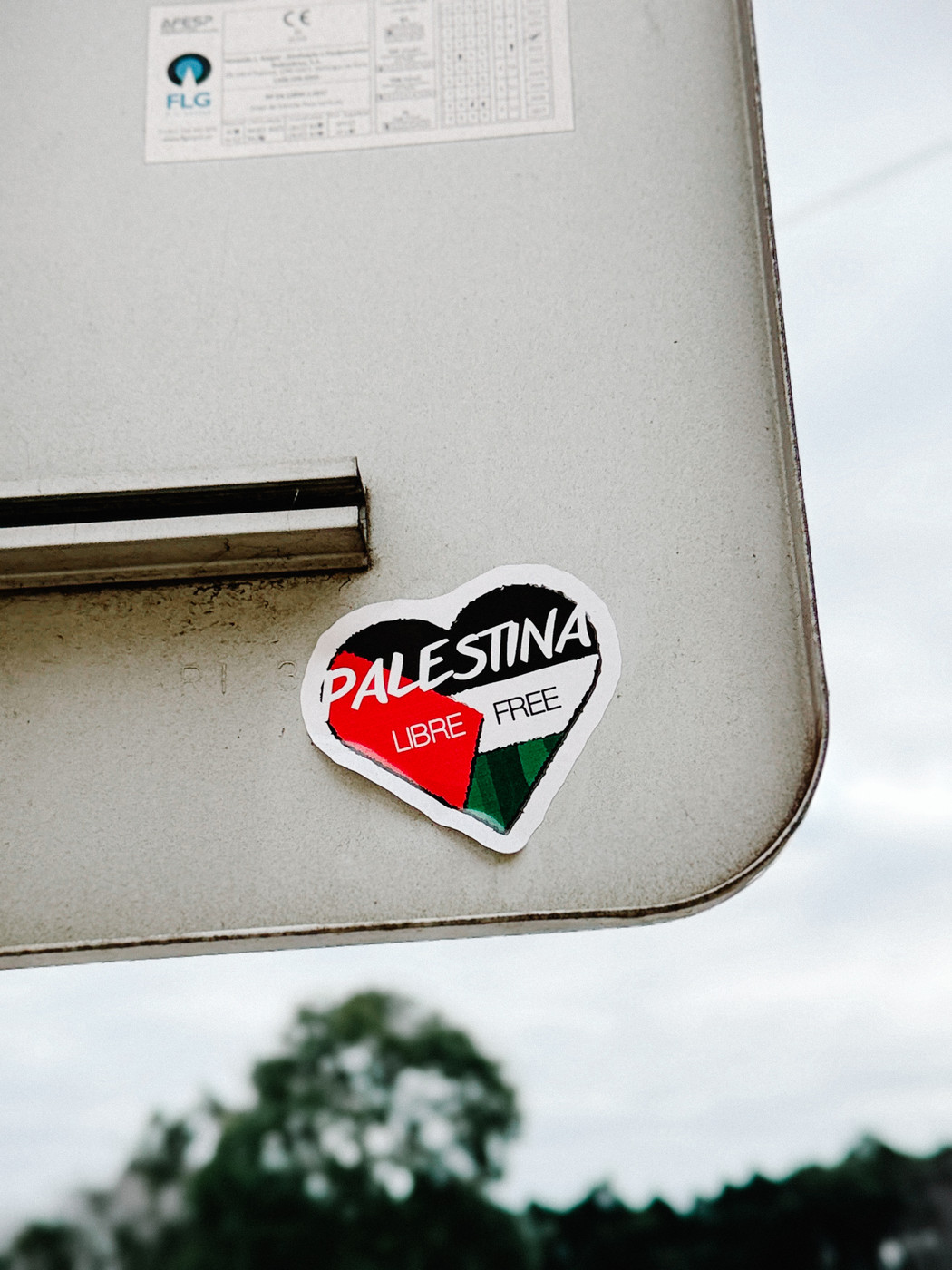 Heart-shaped sticker on a metal surface with the words “Palestina Libre Free” in red, white, black, and green.