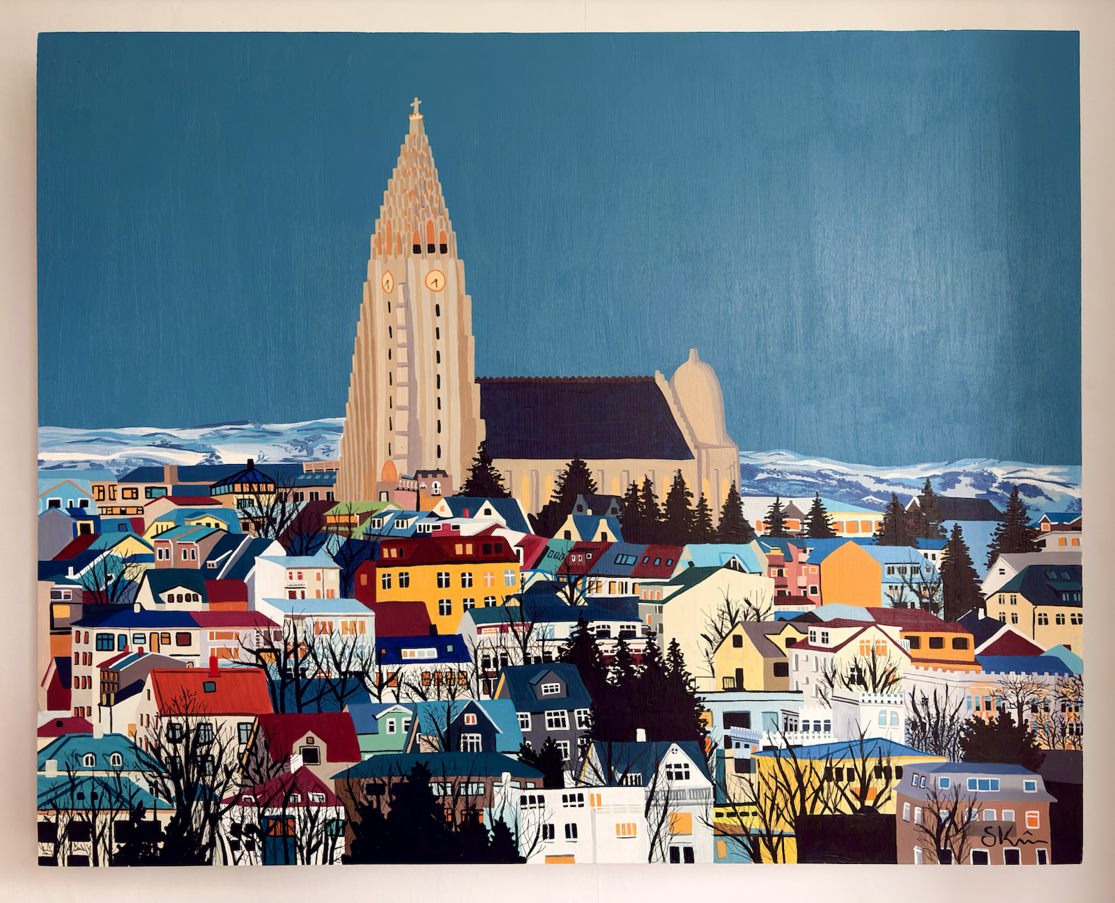 Colourful stylised painting of Reykjavík, with Hallgrímskirkja rising above tightly packed houses and snow-covered mountains beneath a deep blue sky.