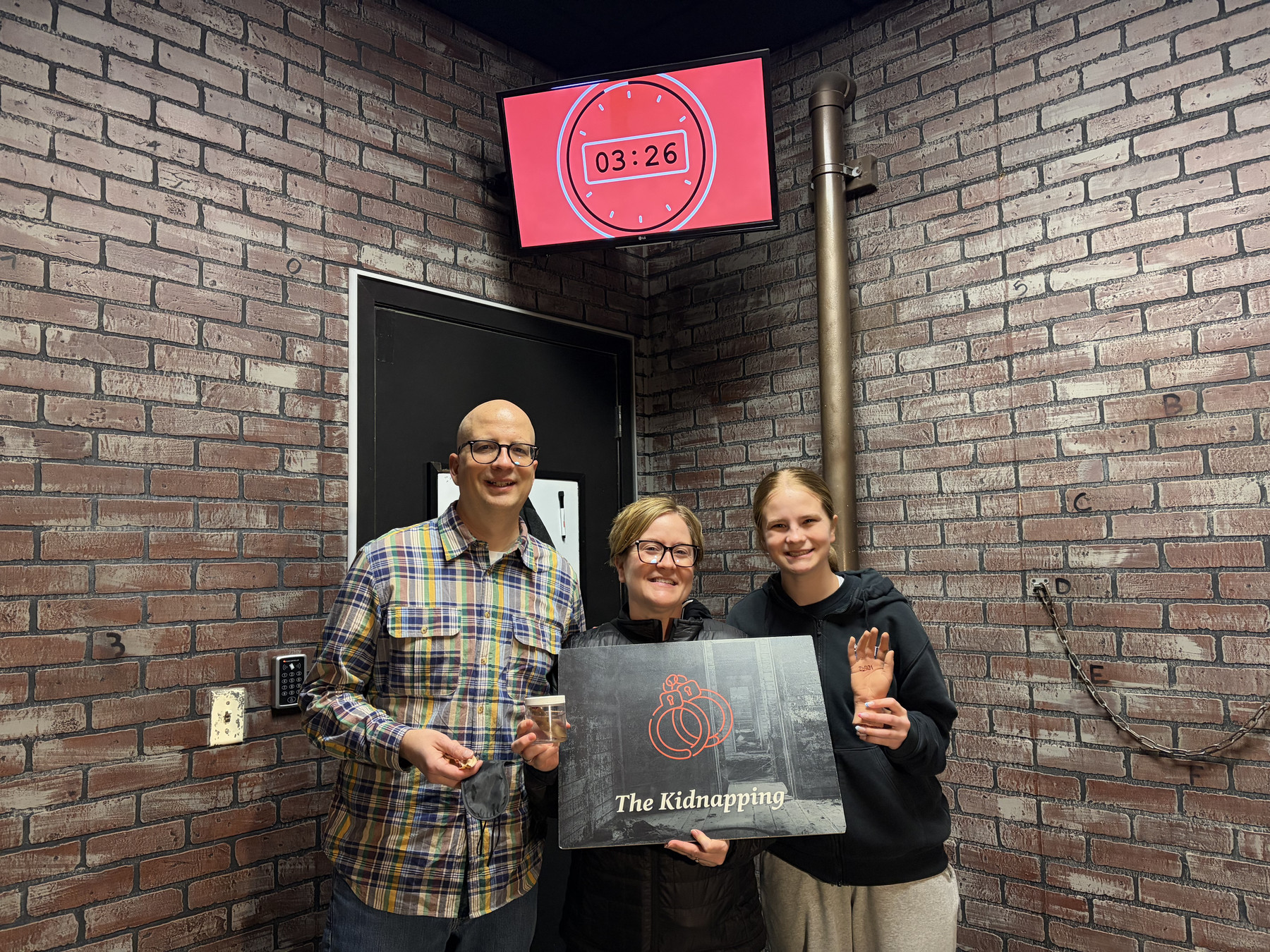 Barry, Jesse, and Emma posing after finishing The Kidnapping escape room.