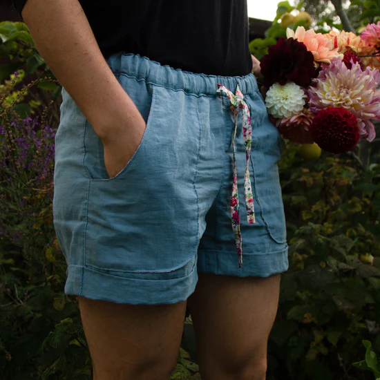 A person modeling blue linen shorts.