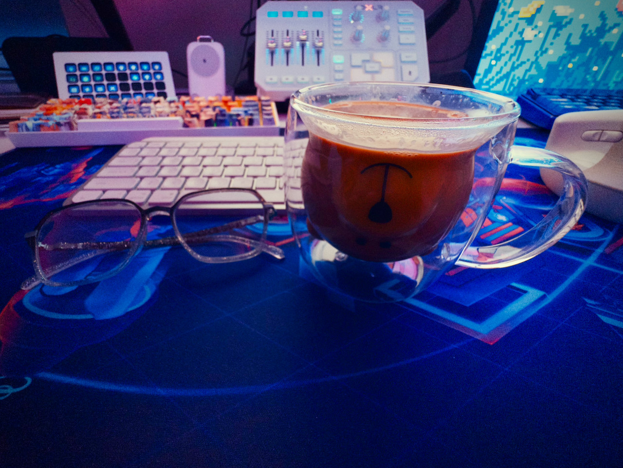 A pair of eyeglasses and coffee in a bear mug