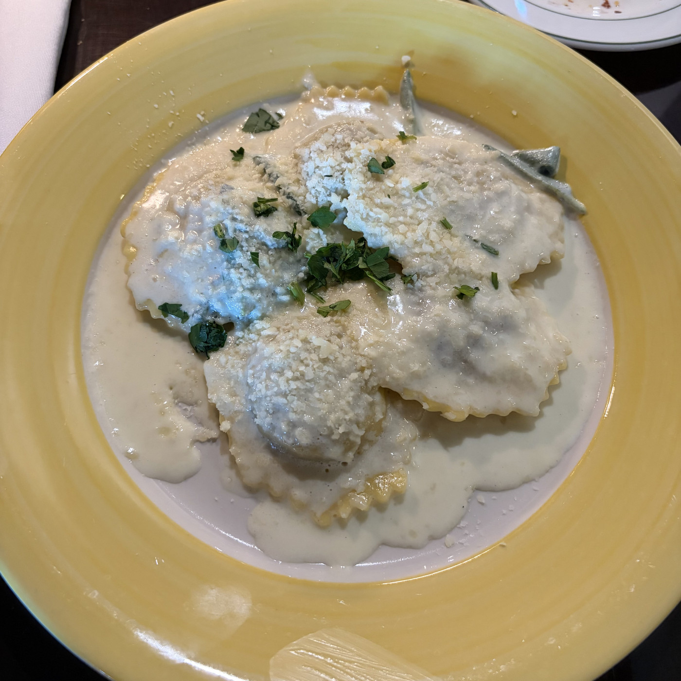 Food picture of ravioli in white sauce.