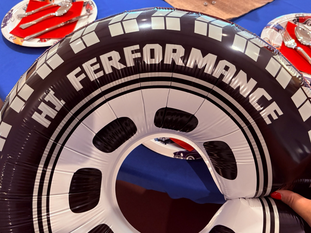 A balloon blown up in the shape of a car tire, but a funny misprint of the words “Hi Ferformance”