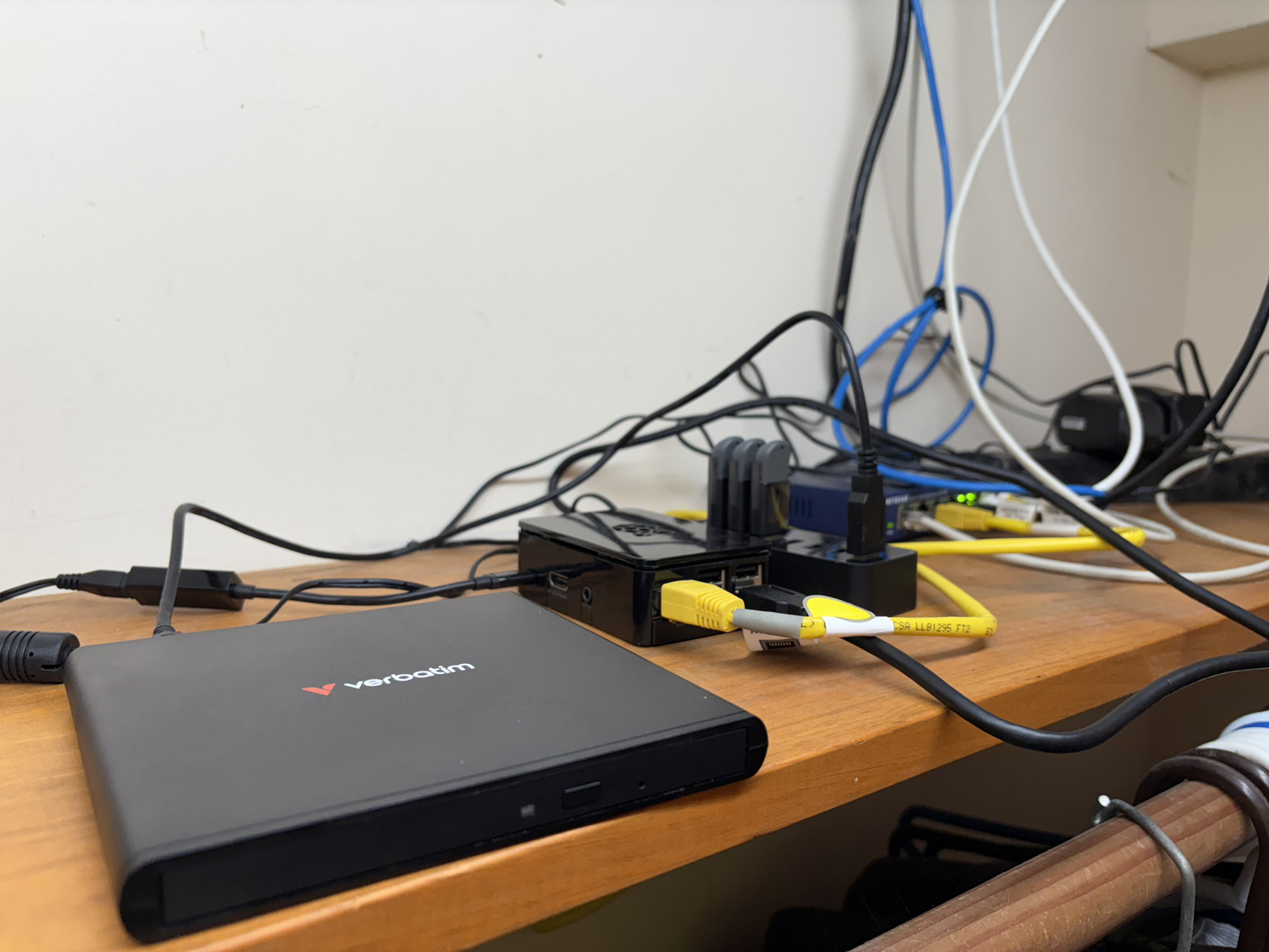 CD-rom drive, Raspberry PI, USB hub, and LAN switch sitting on a shelf